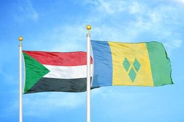 Sudan and Saint Vincent and the Grenadines two flags on flagpoles and blue sky