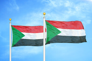 Sudan two flags on flagpoles and blue sky