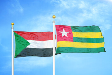 Sudan and Togo two flags on flagpoles and blue sky