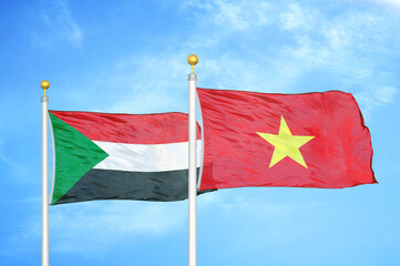 Sudan and Vietnam two flags on flagpoles and blue sky