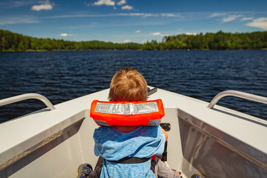 Boy riding in the bow of a boat on Lake Kabetogama in Voyageurs National Park, Minnesota