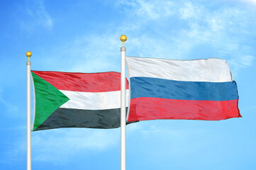 Sudan and Russia two flags on flagpoles and blue sky