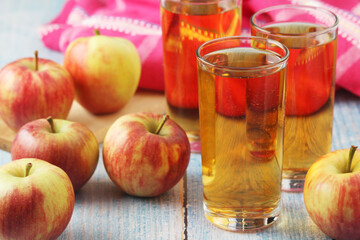 Glasses with apple juice and ripe apples