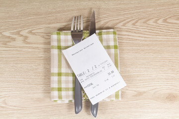 Fork, knife, napkin and restaurant bill on wooden background - 368513758