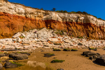 A major, recent rockfall from the white, red and orange stratified cliffs at Old Hunstanton,...