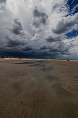 Fototapeta na wymiar Beach scene with clouds rocks ocean and sun