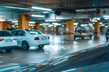 Fototapeta na wymiar Garage car blurred. Car lot parking space in underground city garage. Empty road asphalt background in soft focus. Concrete skeleton for parking car.