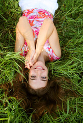 young beautiful girl lays on a grass
