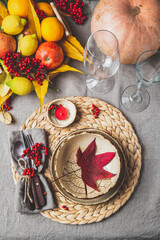 Autumn fall thankisgiving day table setting with pumpkins, fruits and yellow leaves, autumn decoration.