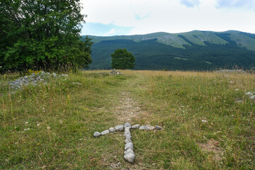 arrow in stones indicating the direction of the path in the san leonardo pass on the mountain area...
