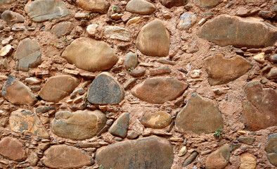 Fototapeta na wymiar ancient medieval wall of a castle or fortress - surface of big stone irregular bricks, and sandy texture background 