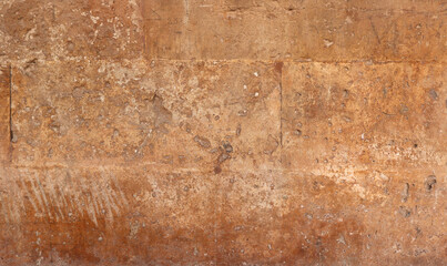 old stone wall with orange and yellow bricks, rugh texture, dirt and scratches for a medieval wallpaper