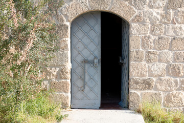 Antique iron door to the mill made of stone