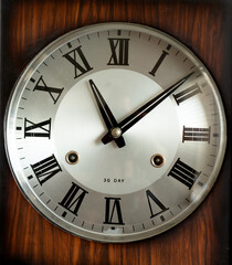 Dial of an antique wall pendulum clock with mechanical winding