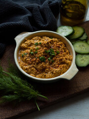 Rustic carrot hummus on wooden board.