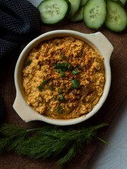 Rustic carrot hummus on wooden board.