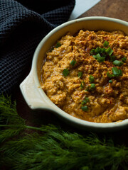 Rustic carrot hummus on wooden board.