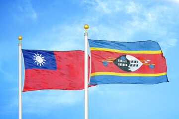 Taiwan and Eswatini Swaziland two flags on flagpoles and blue sky