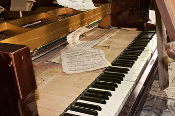 Urban exploration: destroyed piano with a torn music note in an abandoned house