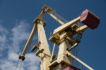 Cargo crane into the port with blue cloudy sky