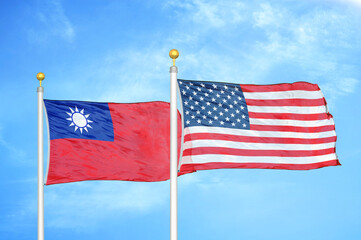 Taiwan and United States two flags on flagpoles and blue sky