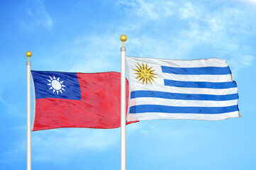Taiwan and Uruguay two flags on flagpoles and blue sky