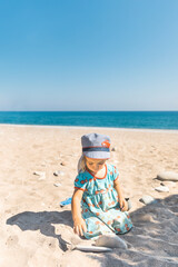 Fototapeta na wymiar Toddler girl playing on beach