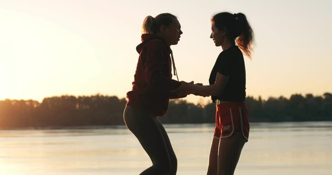 teamwork silhouette of helping hand. sports girls help each over stand up. female power. lesbian love. Friendship