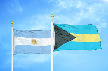 Argentina and Bahamas two flags on flagpoles and blue sky