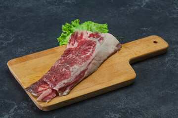 Raw beef bacon over wooden board