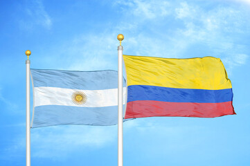 Argentina and Colombia two flags on flagpoles and blue sky