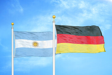 Argentina and Germany two flags on flagpoles and blue sky