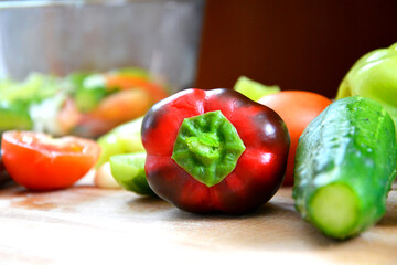 Vegetables in close-up on the cutting Board. Ripe tomatoes, cucumbers, bell peppers, parsley, garlic, ingredients for dietary vitamin salad. Front view.