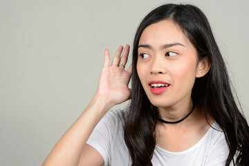 Portrait of happy young beautiful Asian woman