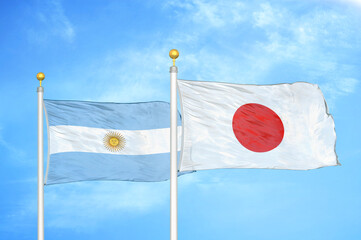 Argentina and Japan two flags on flagpoles and blue sky