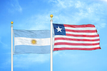 Argentina and Liberia two flags on flagpoles and blue sky