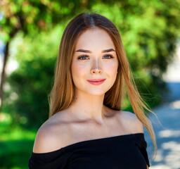 Close up portrait of a young beautiful girl in summer park