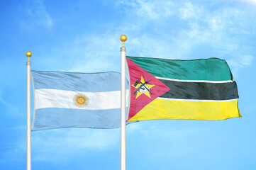 Argentina and Mozambique two flags on flagpoles and blue sky