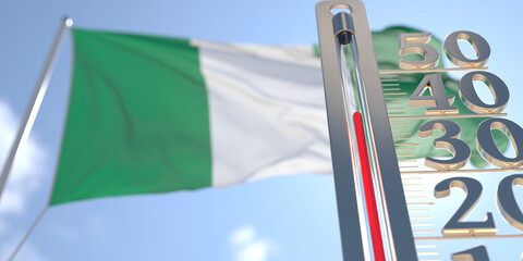 Thermometer shows high air temperature against blurred flag of Nigeria. Hot weather forecast related 3D rendering
