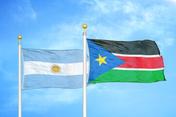 Argentina and South Sudan two flags on flagpoles and blue sky