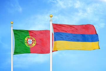 Portugal and Armenia two flags on flagpoles and blue sky