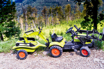 Bielsko Biala, South Poland: Two toy construction truck of children on a hilltop famous view point by hiking track
