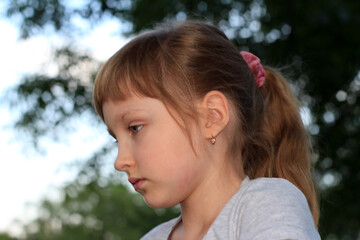 Profile of a little girl in the open air.