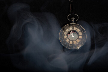 Watch vintage pocket  with smoke on black background.