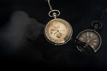Watch vintage pocket  with smoke on black background.