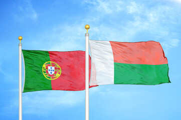 Portugal and Madagascar two flags on flagpoles and blue sky