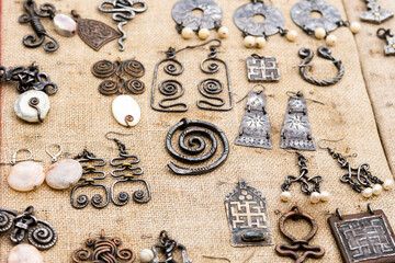 Fototapeta na wymiar medieval jewelry earrings pendant Celtic patterns on a fabric ba
