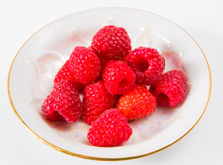 Raspberries on a plate on a white background.