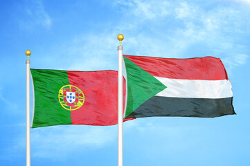 Portugal and Sudan two flags on flagpoles and blue sky