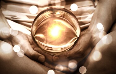 Spiritual background: Fortune teller concept, meditation hand with shining divine light in magic glass ball,sign of powerful mind and peaceful